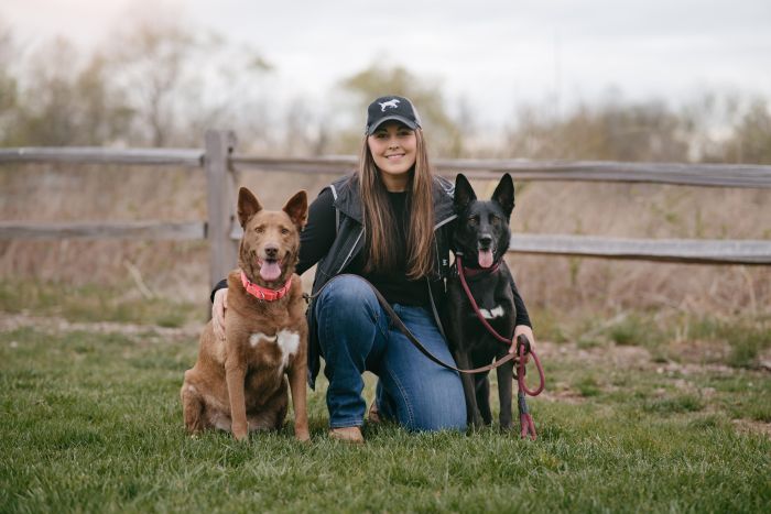 Maggie Quitmeyer with her dogs outdoors at Best Life K9 Training in Illinois